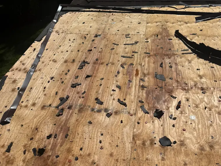 Bare, stained plywood roof decking after tear-off